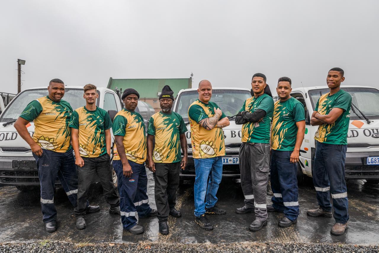Old Oil Boys team beside collection vehicles